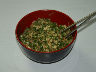 韭菜煎饺,将将蒜沫和韭菜都加入到猪肉碗中，搅拌均匀