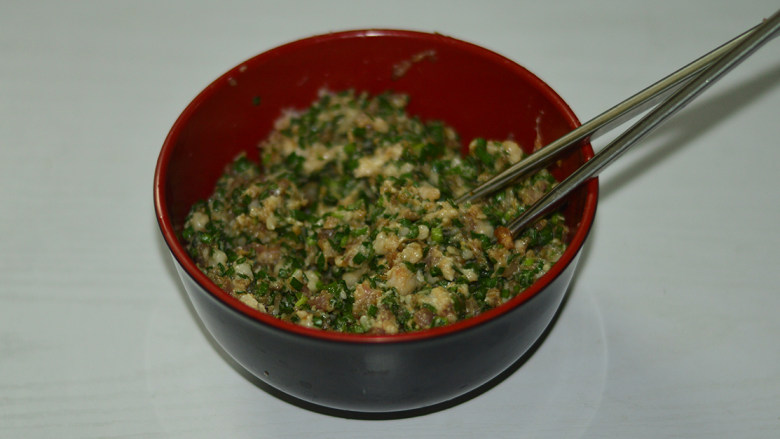 韭菜煎饺,将将蒜沫和韭菜都加入到猪肉碗中，搅拌均匀