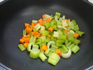 西芹胡萝卜炒腰果,倒入西芹和胡萝卜翻炒均匀。