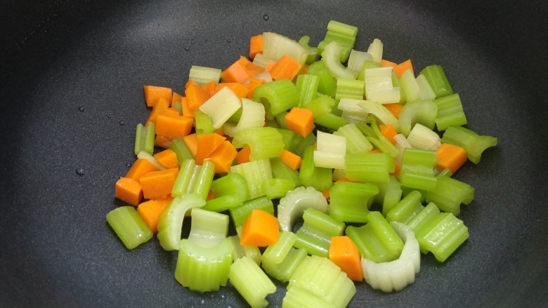 西芹胡萝卜炒腰果,倒入西芹和胡萝卜翻炒均匀。