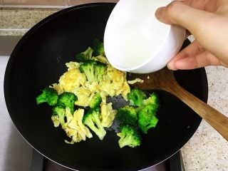 简单快手家常菜—西兰花炒蛋,倒入炒好的鸡蛋，再倒入适量的清水