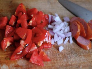 快手正餐  番茄绿豆芽火腿小炒,把番茄洗净后用刀切块，洋葱切碎，木耳提前泡发好洗净，火腿肠切片备用；
