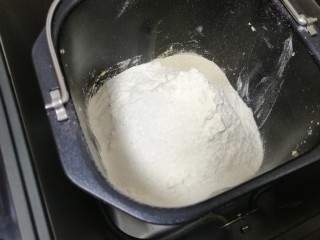 螺旋豆沙包,将牛奶倒入面包机桶内，加入面粉、发酵粉和糖。