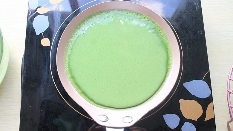 那一抹毛巾卷的绿,倒入一小勺面糊，晃动平底锅均匀铺满，煎好后依次摊凉即可