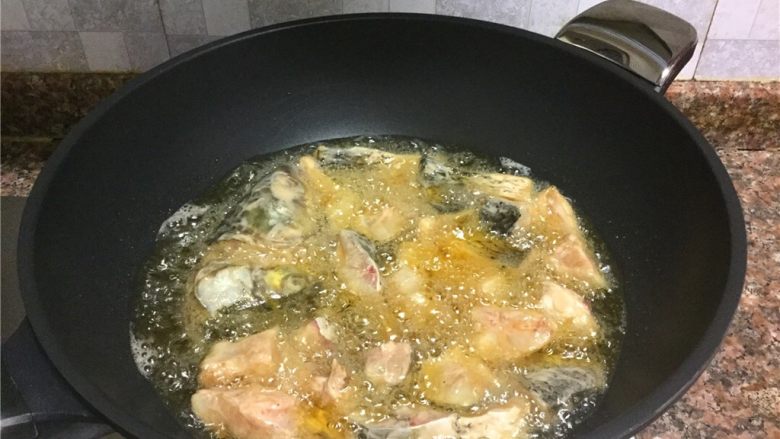 泡椒豆豉干烧鱼,放入鱼块炸至表面微黄捞出。