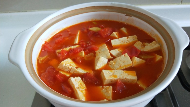快手正餐 番茄花花虾仁豆腐煲,在倒入砂锅，加入适量开水。加入豆腐煮开。