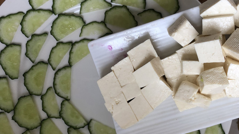富贵豆腐的做法,将切好的豆腐块倒入摆好盘的黄瓜盘中间。