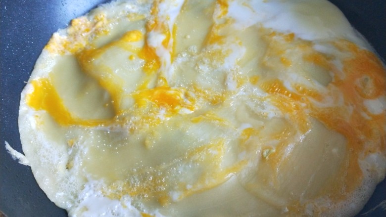 快手小食 鸡蛋煎饼果子,平底锅烧热倒入适量油，在舀一大勺面糊摊开，摊开后等面糊固定在打入一个鸡蛋摊均匀。
