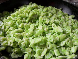 芸豆包子,锅里放油，和平时炒菜一样多就可以，把芸豆粒炒至变成漂亮的绿色，出锅晾凉备用，