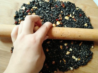 黑芝麻糖,把芝麻倒在菜板上 快速擀平，动作一定要快。