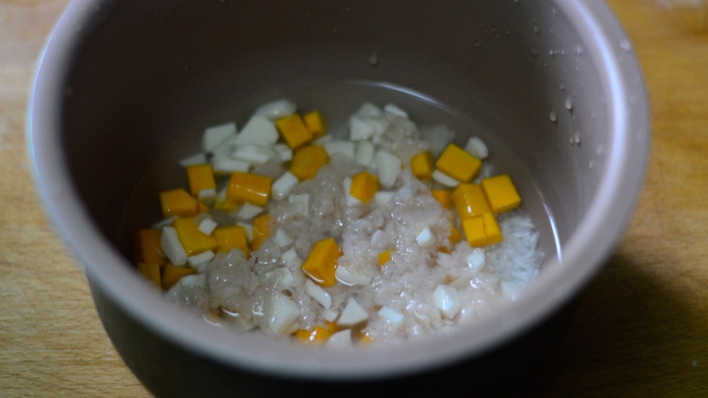 南瓜山药焖饭（辅食）,将浸泡大米的水倒掉，重新注入清水（要比平时煮饭的水量多一点）再将山药、南瓜和鸡肉均匀的铺在大米上面