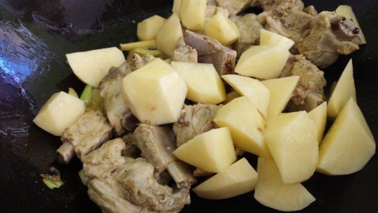 土豆炖排骨,把排骨炒匀，然后加入土豆块。