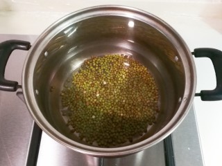 快手小食   去火百合绿豆汤,锅中放入绿豆和一碗冷水一起烧开，再放入两碗冷水烧开