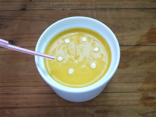 南瓜奶油浓汤,这边教大家一个拉花的小技巧，用吸管粘些淡奶油，在汤中做几个点