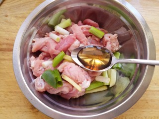 软炸里脊,接着把里脊肉放入盆中，加入葱和姜。再加一勺料酒。