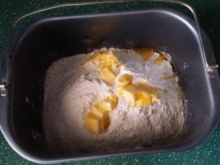 蓝莓酱玫瑰花面包#一次揉面&一次发酵#,然后依次倒入牛奶酵母液、高筋面粉、奶粉和黄油粒