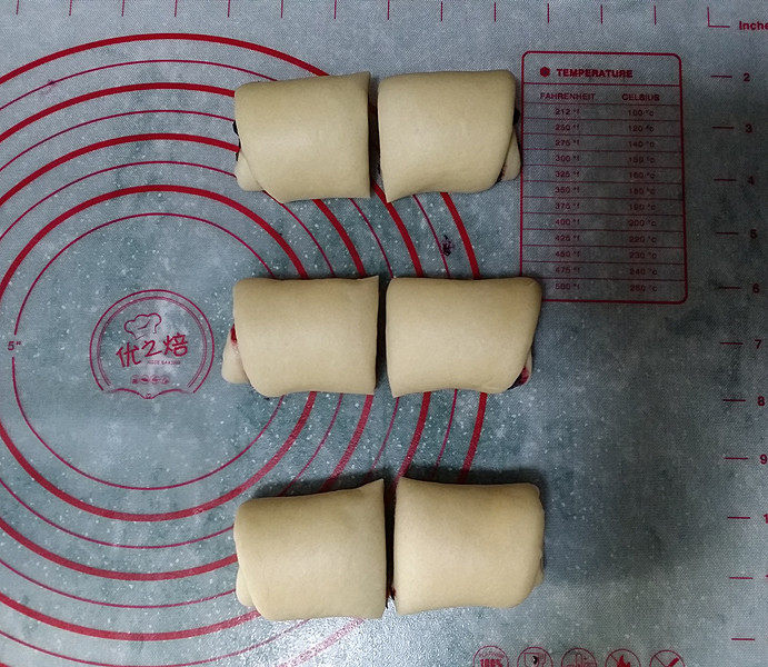 蓝莓酱玫瑰花面包#一次揉面&一次发酵#,3个面团一起卷好后，用刮板从每卷的中间切开，如图