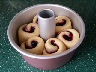 蓝莓酱玫瑰花面包#一次揉面&一次发酵#,放至烤箱中，再放碗温水，采用自然发酵至8分满取出，表面刷层全蛋液