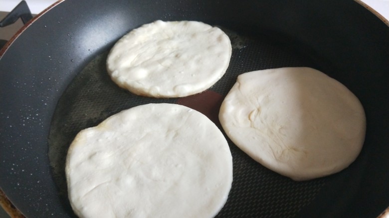 快手早餐  鸡蛋沾饼,平底锅烧热放入小饼，刷均匀油。