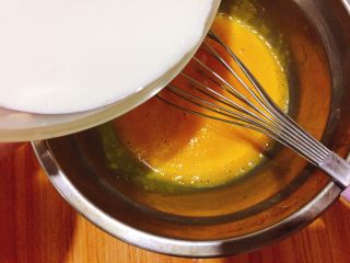 快手小食  芒果蛋挞,蛋黄打散后加入牛奶混合液，可以边倒边混合，最后筛入低筋再次搅拌均匀。