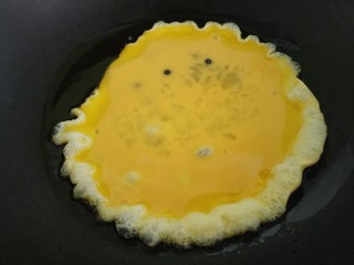 大葱炒鸡蛋,把鸡蛋液倒进锅内。