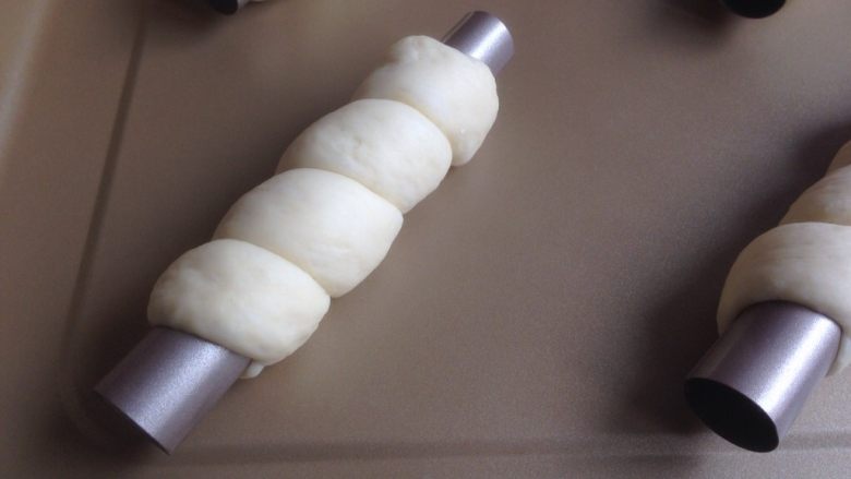 奥利奥奶油面包筒,面团搓成到32至34厘米左右，缠绕在管上几圈。放入烤箱发酵40分钟。