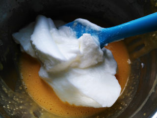 椰蓉蜂蜜蛋糕卷,将三分之一蛋白霜加入蛋黄糊中，用刮刀搅拌均匀