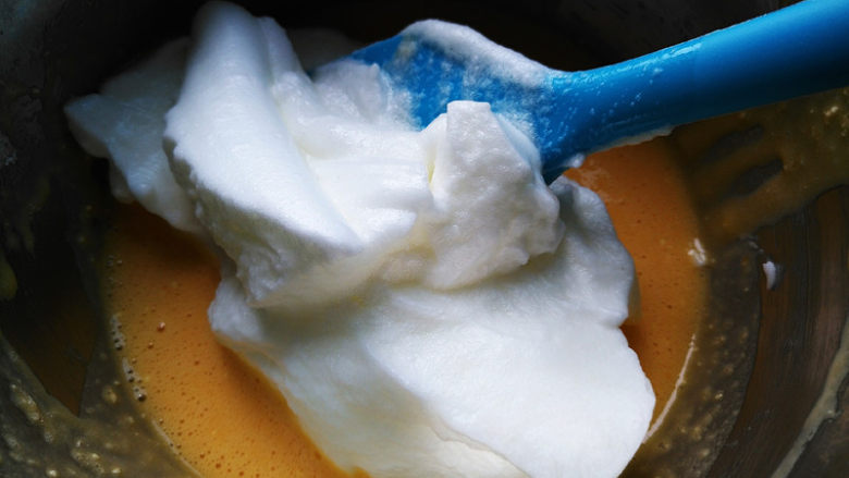 椰蓉蜂蜜蛋糕卷,将三分之一蛋白霜加入蛋黄糊中，用刮刀搅拌均匀