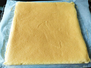 椰蓉蜂蜜蛋糕卷,表面上色均匀后即可出炉，将蛋糕从烤盘移到冷却网上，撕开四周油纸