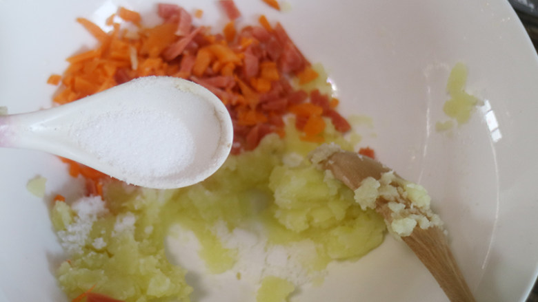 香糯土豆火腿饼,把胡萝卜和香肠粒放入土豆呢搅拌均匀，再加入适量盐。