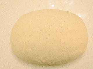 健康黑麦乡村面包,面团倒在撒较多干粉台面上，左右折叠，再翻面，移到托盘上。