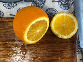 宝宝爱吃的香橙蒸蛋,把里面的果肉挖出来，把果肉放入挤橙汁的杯中，把果汁挤出来。