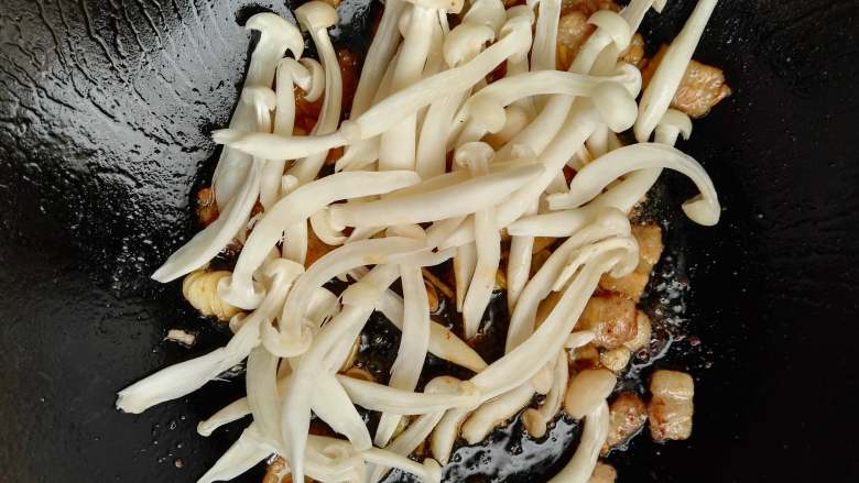 清热去火+解馋+苦瓜白玉菇炒肉,加入白玉菇，翻炒均匀。