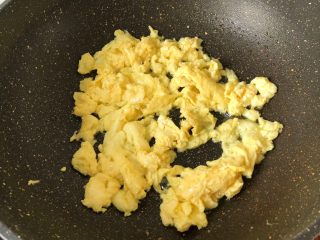 番茄炒年糕,锅中放油烧热鸡蛋放进去煎定型之后用筷子搅拌散开装盘