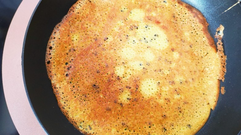 平底锅版黑芝麻蛋卷,平底锅预热后倒入少许稀面糊，用手持锅摇匀，摊至至两面金黄