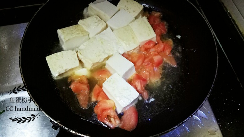 甜酸豆腐,加入番茄块到锅里，用铲子轻轻的来回推动豆腐和番茄，番茄开始出水后用过盖子盖上闷煮约三分钟。