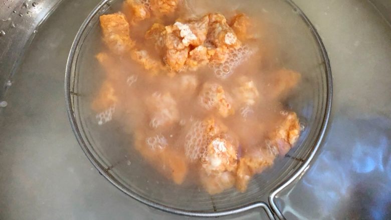 劲爆鸡米花,准备一盆水，把漏勺放到水里浸泡3秒马上拿起来，让鸡块均匀湿透