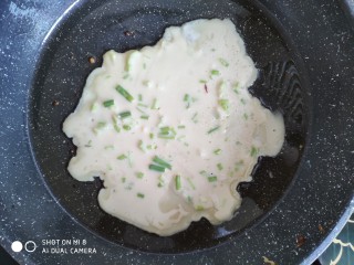 快手早餐之葱花饼,锅里刷上一层油，用大勺子舀面糊入锅，旋转一下锅，让面糊均匀，一面煎好在翻面煎另一面