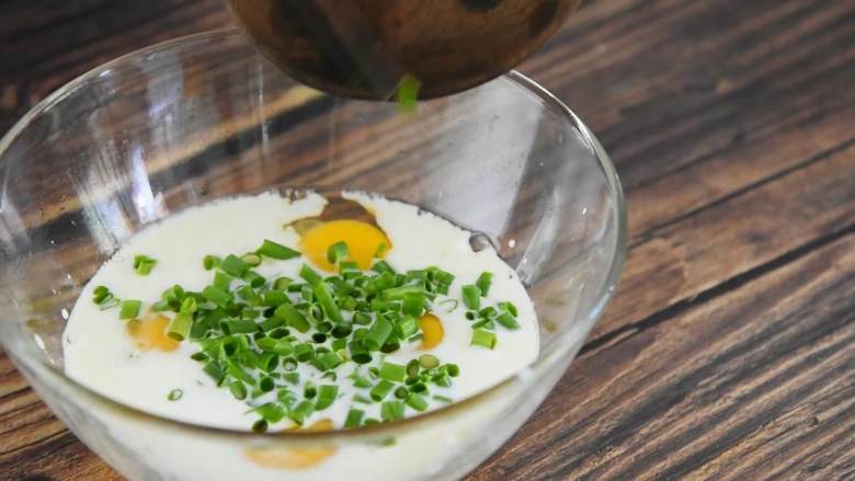 葱香芝士蛋卷—色彩丰富口感更丰富,碗中打入个鸡蛋，倒入牛奶、火腿丁，加入葱花、盐，打散拌匀。