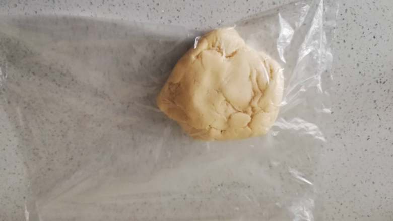 糖霜饼干之平整饼干底,将面团放入保鲜袋中，用擀面杖擀成3-4毫米的薄片。