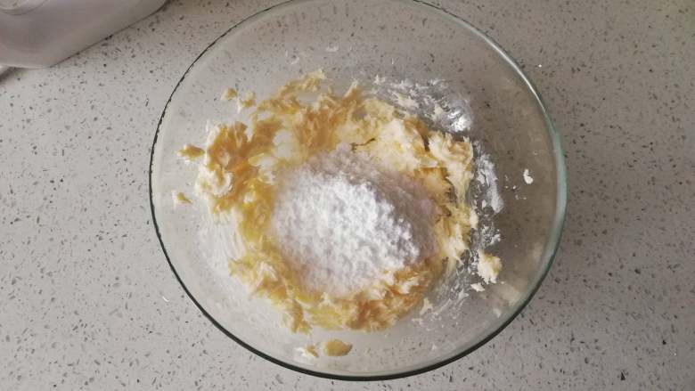 糖霜饼干之平整饼干底,加入糖粉，用打蛋器混合均匀，打至黄油颜色变浅，体积微微膨胀。