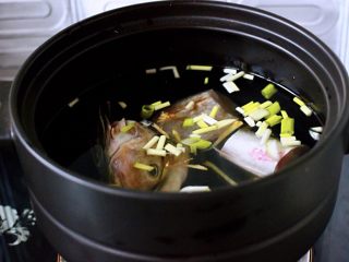 烟台美食-红蟹鱼丝瓜煲,砂锅里加入适量清水，放入切块的红蟹鱼，再加入葱姜