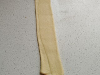 椰蓉炸面包,再用擀面杖从中间向两端擀薄擀长。