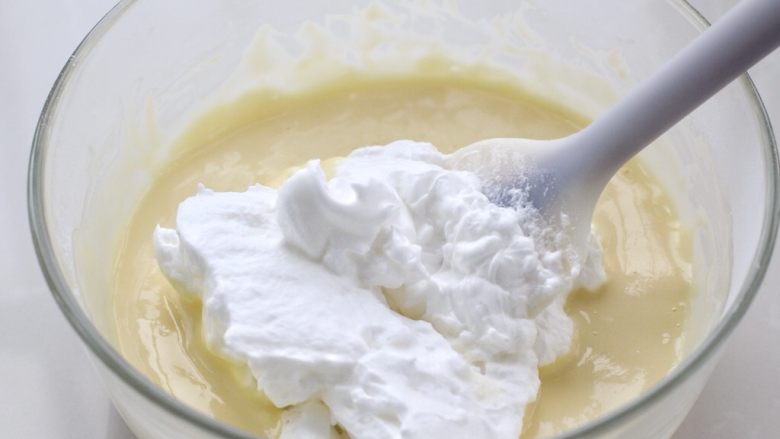 酸奶蛋糕,取三分之一的蛋白霜放入蛋黄糊中，用刮刀上下翻拌均匀