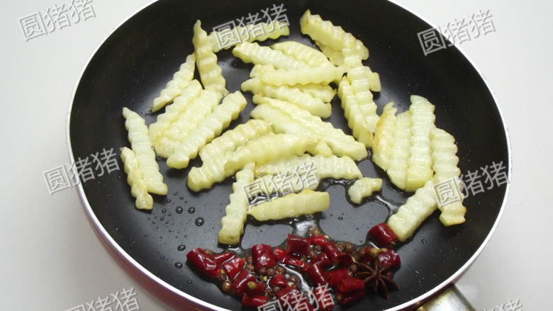 干煸土豆条,土豆拨开，将红椒段，花椒在锅的一侧用油爆香。