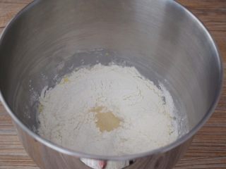 牛奶面包,把材料除了黄油外，都放入和面桶，顺序为纯牛奶、鸡蛋液、糖和盐对角放，然后放面粉，酵母放最上面