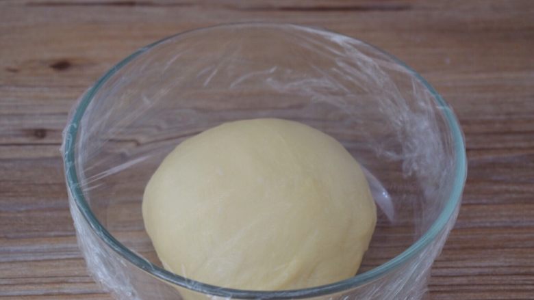牛奶面包,取出面团揉圆盖上保鲜膜放在温暖处发酵至两倍大左右