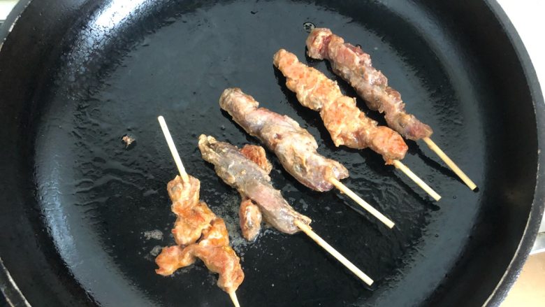 孜然猪肉串,将白芝麻撒在烤好的肉串上面，即可摆盘。