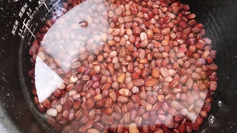 糖渍蜜红豆,加入高过红豆一指的水，放入电饭锅里用粥汤功能2个小时