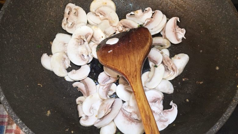鲜虾蘑菇炒面,锅中烧热油放蘑菇片，大火翻炒至水分析出
